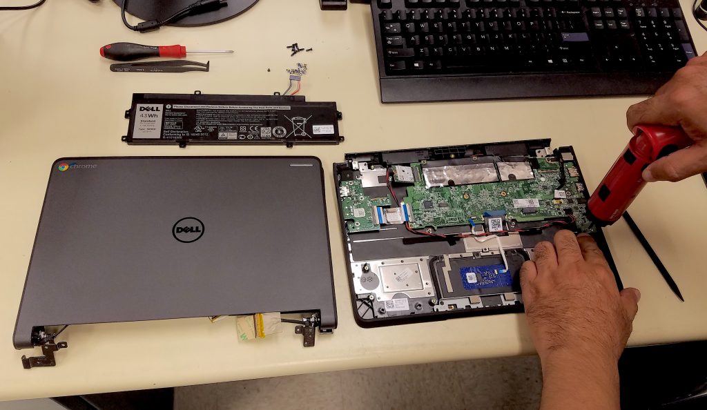 Hands of a CRC technician repair a Dell computer