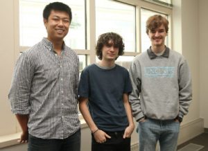Three student developers pose