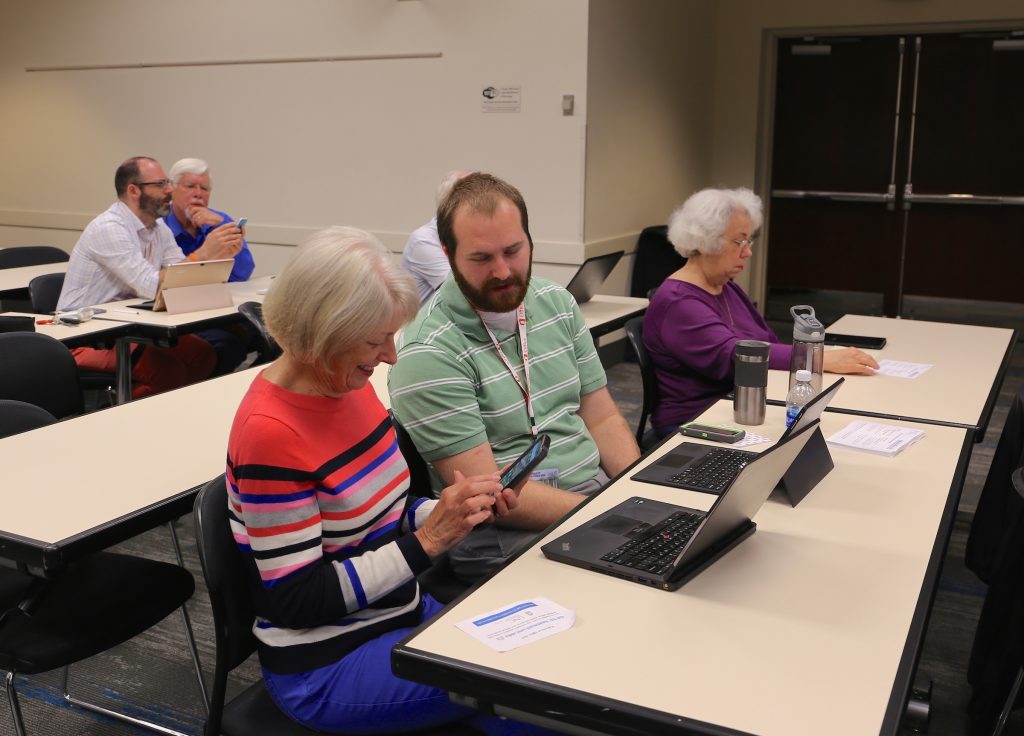 Two Field Team members assist retirees at an Office 365 migration event.