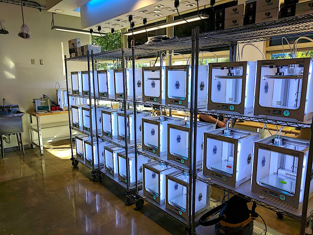 The Blue Makerspace has 22 3-D printers on this rack and two larger 3-D printers on the table beyond.