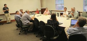Participants converse around a conference table at one of the breakout sessions.