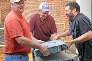 Mike Harris, Charles Woody and Mike Whitfield move computing equipment in March 2020