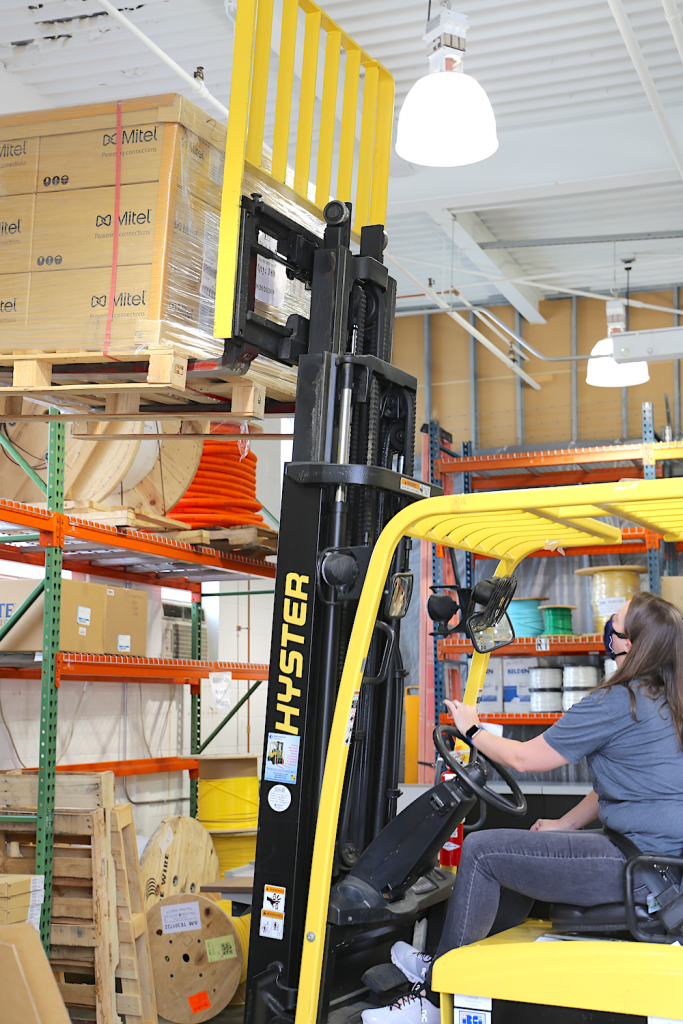 Nathalie Donaghy on forklift getting down a crate of phones