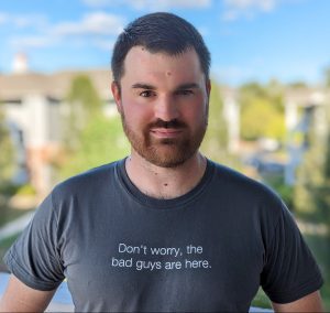 Jared Perdue wears a t-shirt that reads "Don't worry, the bad guys are here"