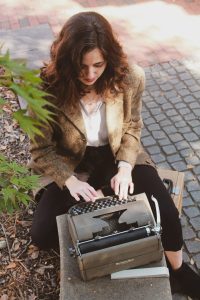 Alexandra Corbett types on a vintage typewriter