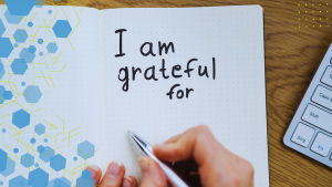 A woman writes "I am grateful for" in a journal
