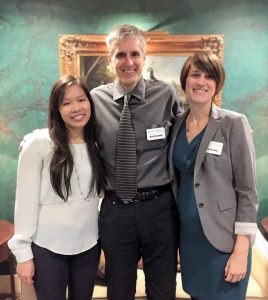 At the 2018 Faculty Showcase, Bob Henshaw stands with his arms around the shoulders of Thao Nghi Tu and Emily Boehm