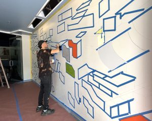 Artist ILL.DES hand paints sections of the mural