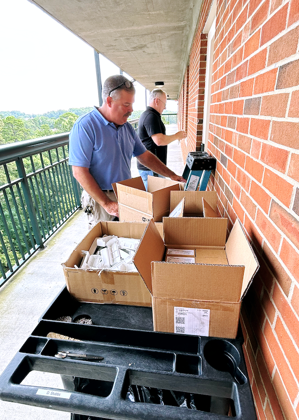 ITS staff Kevin Clayton and Dale Oxendine roll a cart of supplies on one of the Morrison balconies