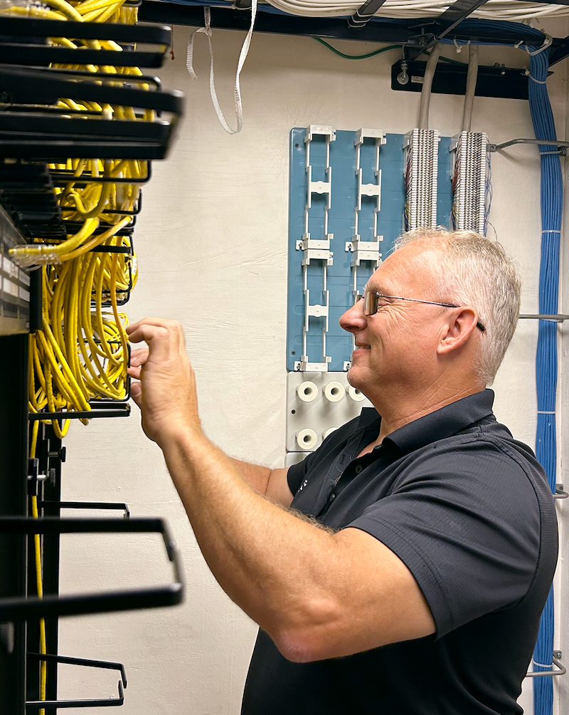 Dale Oxendine connects new Ethernet cables in a Morrison server room