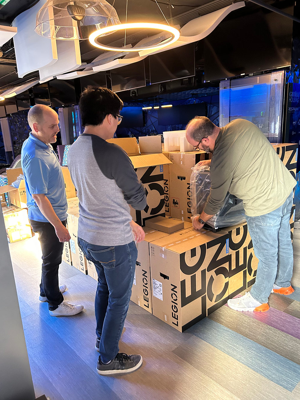 ResNET staffers unbox a gaming desktop from a stack of boxes